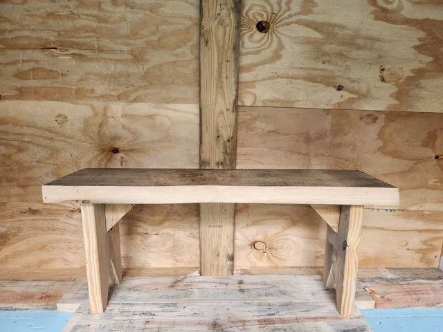 Natural wood bench shown from the front in the workshop