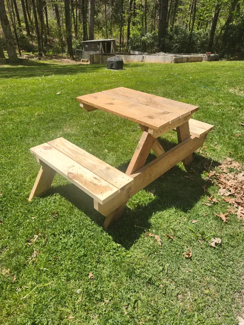 Bare-wood picnic-style outdoor table in a garden