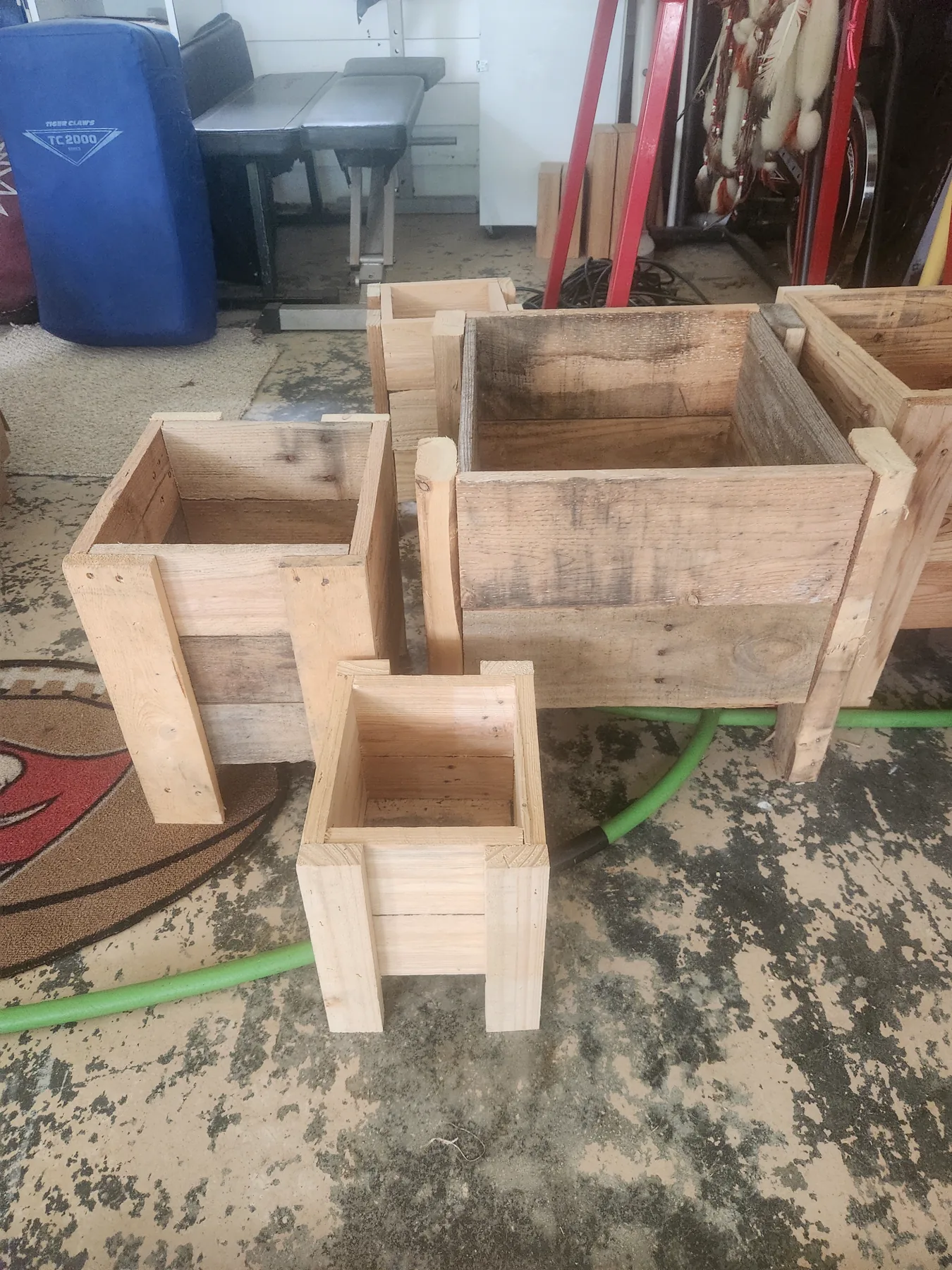 Several unfinished wood planters in different sizes inside the Creations by Hatch workshop